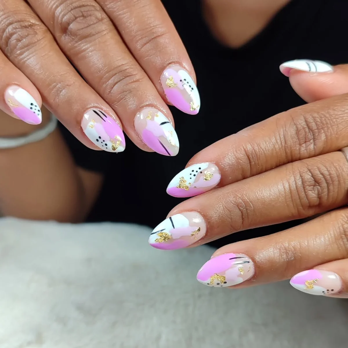 Manos con uñas en tonos rosa, lila y blanco realizadas en FB Beauty Studio